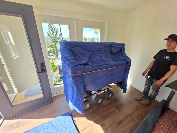Piano movers carefully moving an upright piano